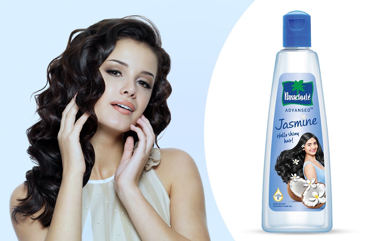 A happy curly woman with Parachute Advansed Jasmine Hair Oil