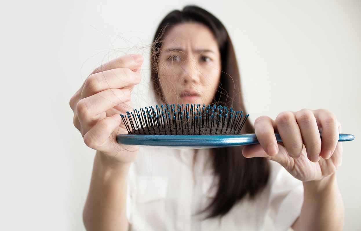 A woman combing, broken hair in comb-seemingly irritated woman