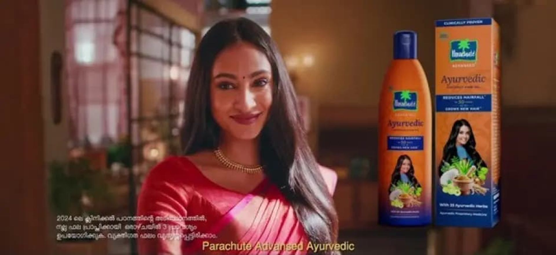 A smiling woman with gorgeous long hair after using Parachute Advansed Ayurvedic Oil 