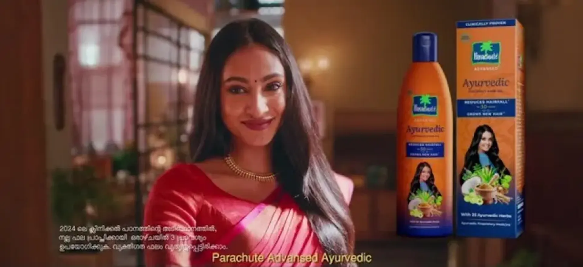 A smiling woman with gorgeous long hair after using Parachute Advansed Ayurvedic Oil 