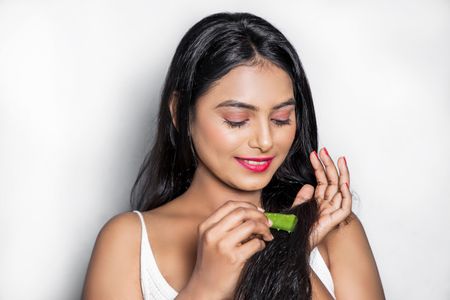 Girl applying aloe vera on her hair