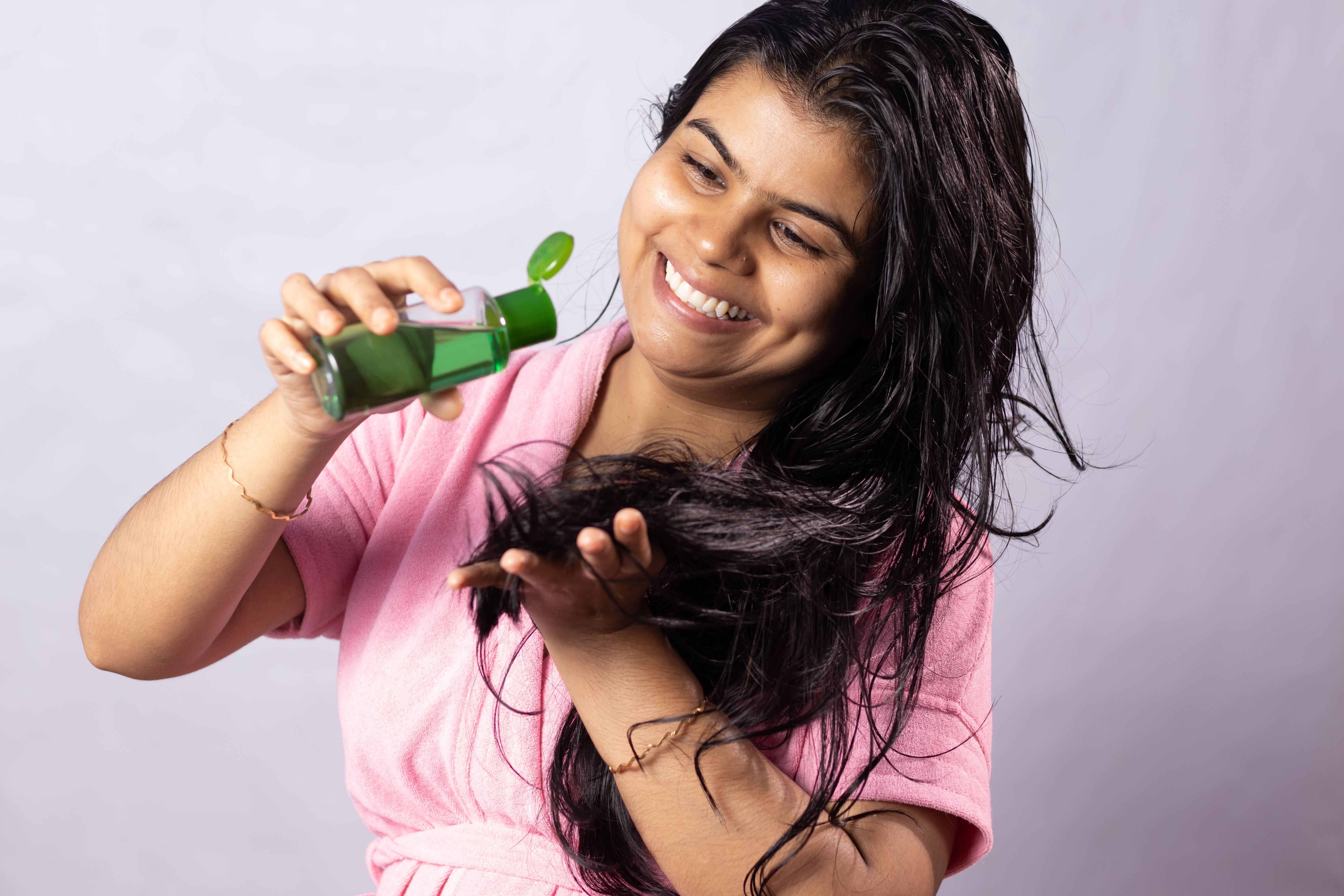 Girl applying hair oil for Summer Hair Fall