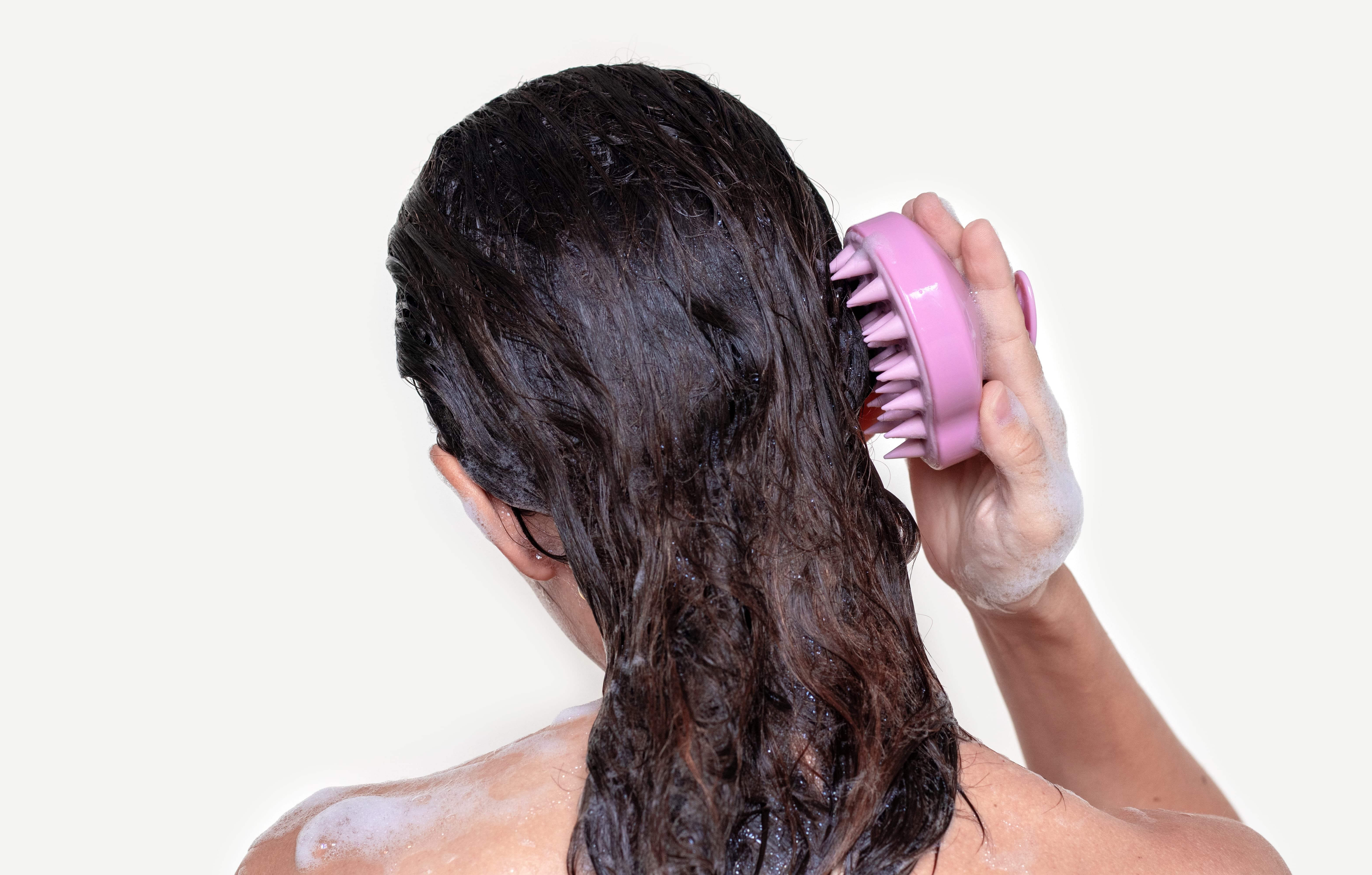 Girl washing her hair using hair scrubber