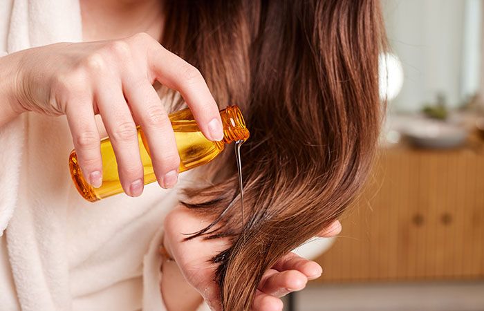 Girl Applying Coconut Hair Oil on her hair