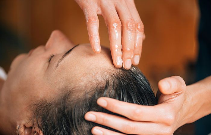 Girl applying Damage Protection Hair Oil on her hair