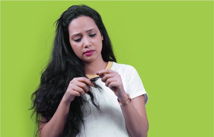 woman looking at her split ends